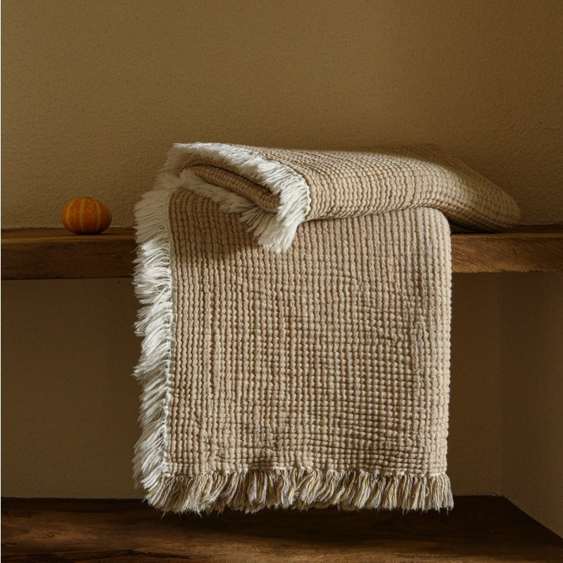 A woven cotton and linen fringed blanket
