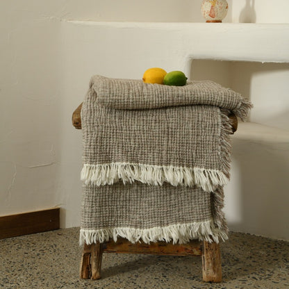 A woven cotton and linen fringed blanket