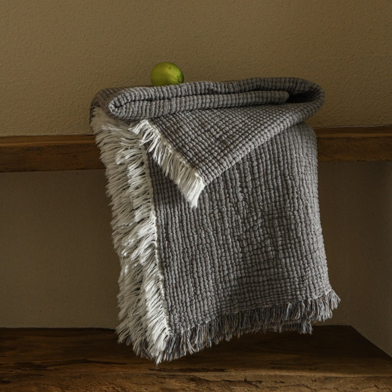 A woven cotton and linen fringed blanket