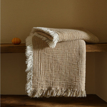 A woven cotton and linen fringed blanket