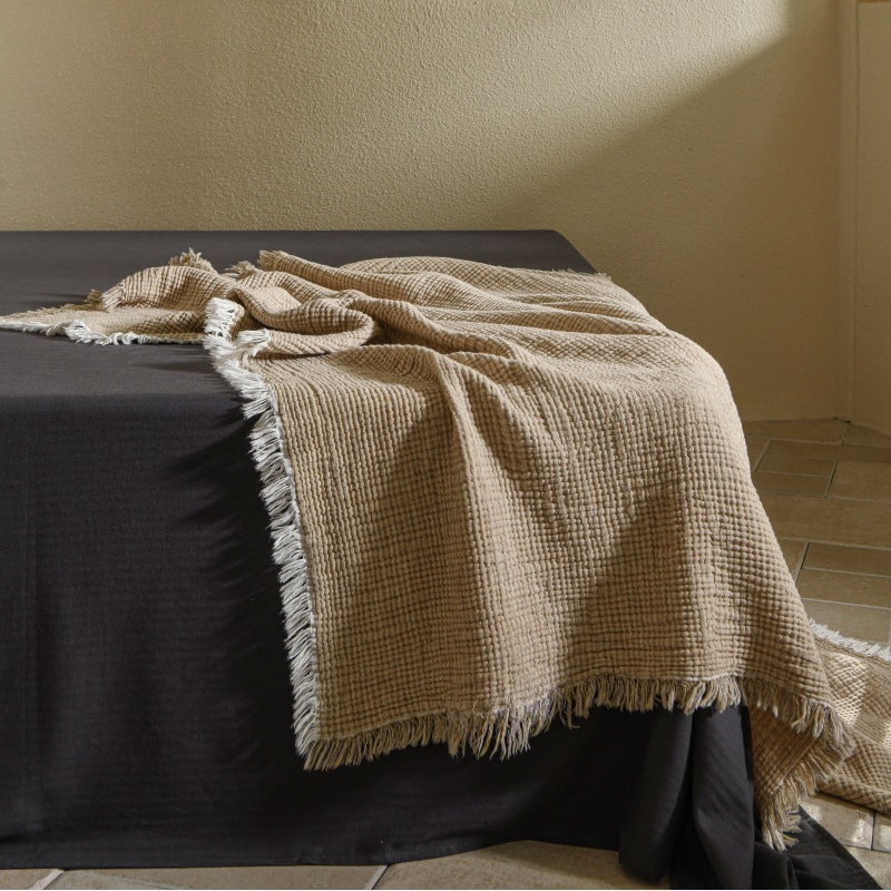 A woven cotton and linen fringed blanket